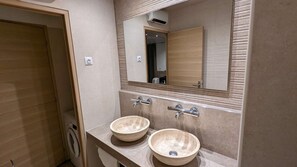 Enjoy a sleek bathroom with two sinks, a large mirror, and a washing machine for added convenience.