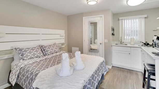 Una camera da letto con un letto, un comodino e un angolo cottura attrezzato con lavello e piano di lavoro.