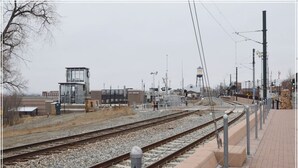 Una stazione ferroviaria con diverse banchine, una torre del segnale e una passerella pedonale.