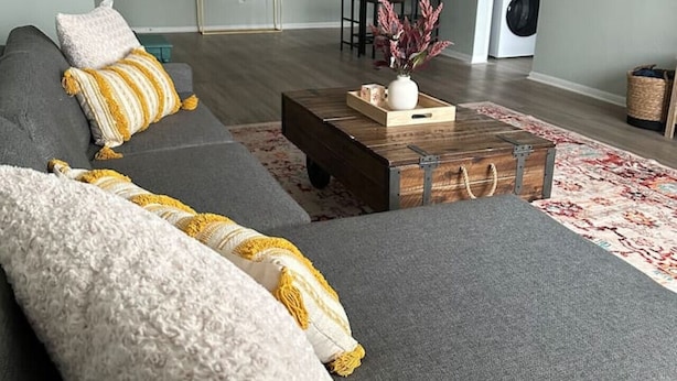 A modern living room with a grey sofa, a wooden coffee table, and a patterned rug. - Lakewood Gem: Furnished Haven! Perfect for Month Long Stays! (Lakewood)