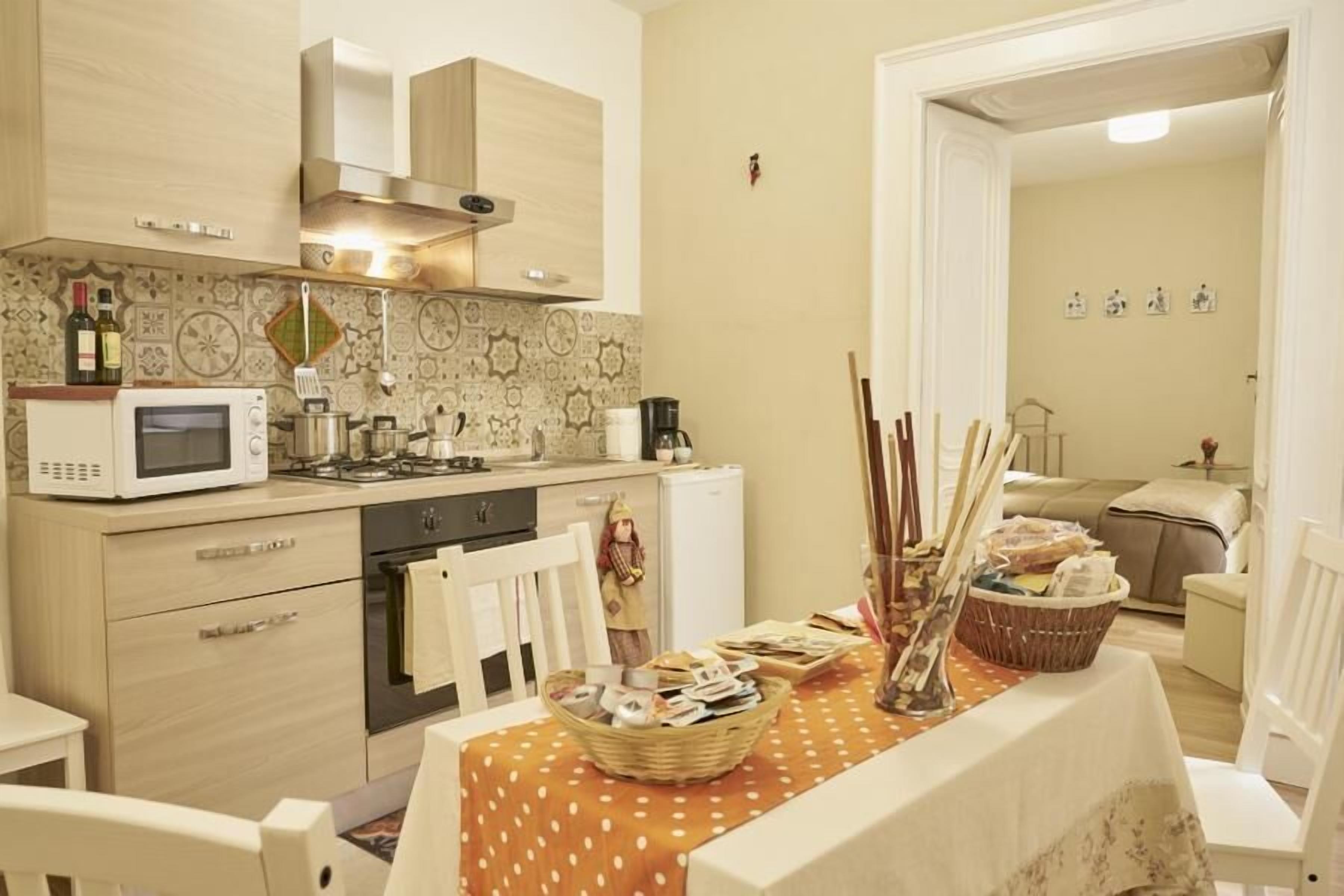 A compact kitchen with a microwave, stove, and a dining area with a table set for two.
