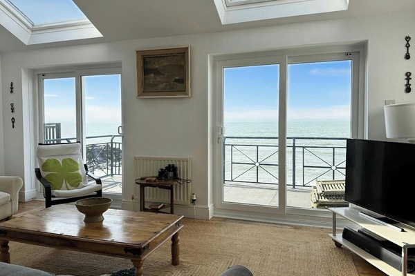 Sitting room with sofa, coffee table, tv, doors to terrace and sea view