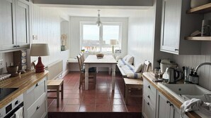Une cuisine équipée d’une table à manger, de chaises, d’un banc, d’un évier et de placards.