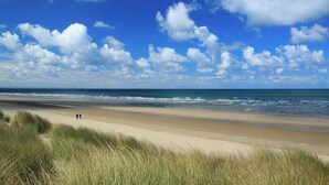 Une plage avec un ciel dégagé et une mer calme.