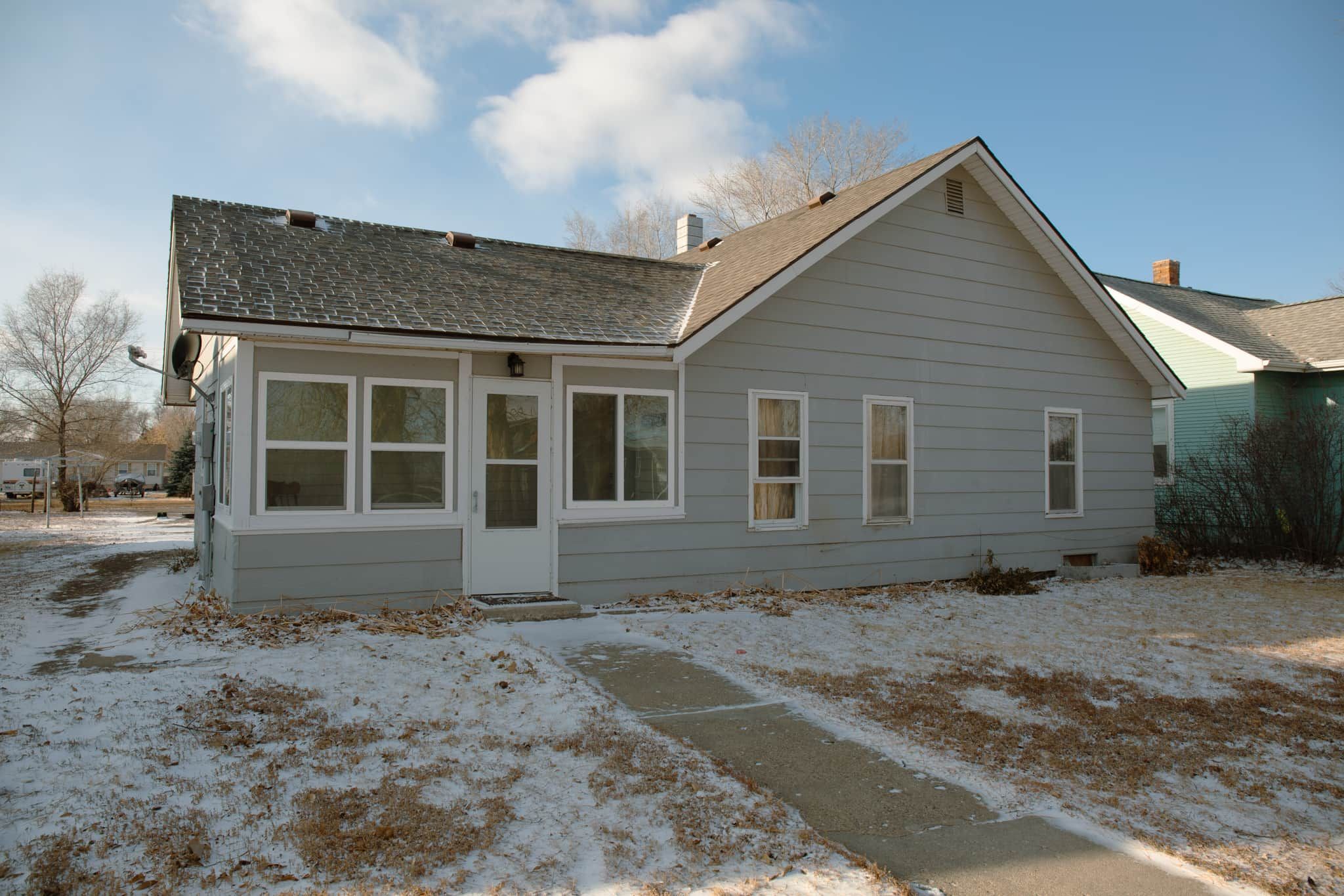 A single-story house with a front door, a small porch, and a garage.