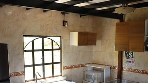 A compact kitchen with a sink, microwave, stove, and cabinets. - FINCA VACACIONAL GUANANI (Socorro)