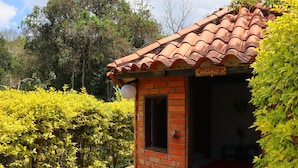 A small brick building with a tiled roof, a door, and a window. - FINCA VACACIONAL GUANANI (Socorro)
