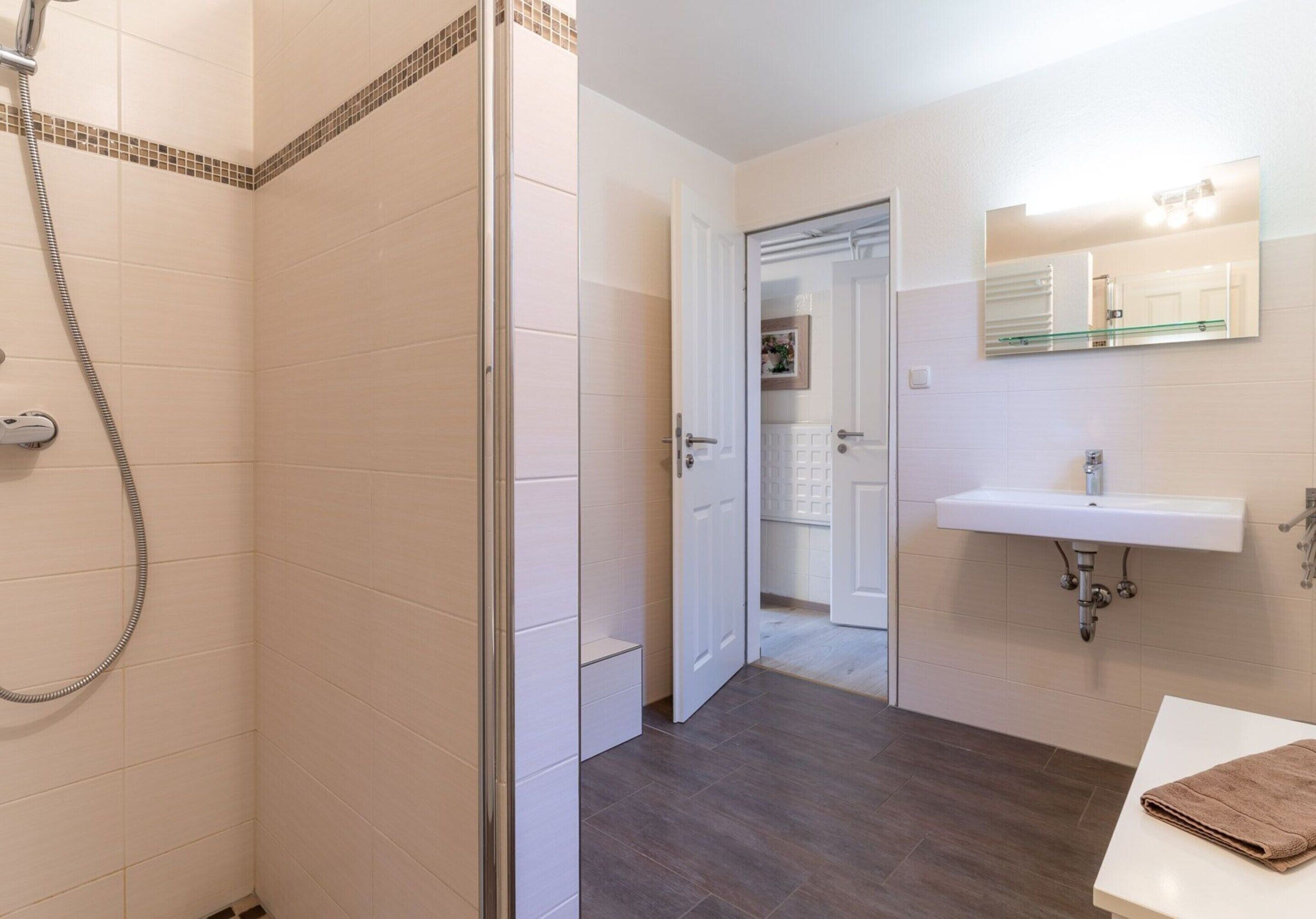 A bathroom with a shower, a sink, and a mirror.