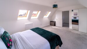 Een slaapkamer met een bed, dakramen, een radiator en een kledingkast.