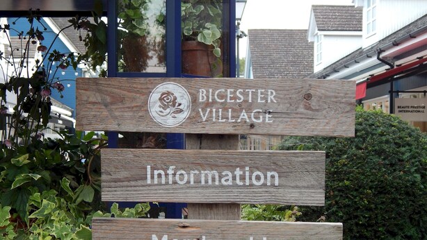 A wooden signpost with 'BICESTER VILLAGE' and 'Information' and 'Membership' directions. - Shop & Stay at Bicester Village near our 3 Bed Home-  Pass the Keys (Bicester)