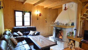 A cozy cabin interior with a fireplace, leather sofa, and wooden walls. - Holiday Home With Fireplace and Private Garden (gmina Stężyca)