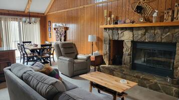 TV connectée, cheminée, livres, écrans d'ordinateur