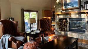 Una sala de estar acogedora con sillones de cuero, una mesa de centro y una chimenea.