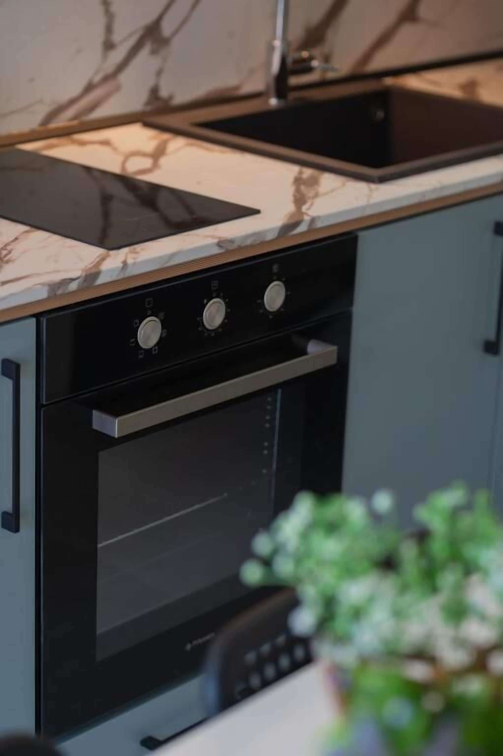A modern kitchen with a built-in oven, a stovetop, and a microwave.