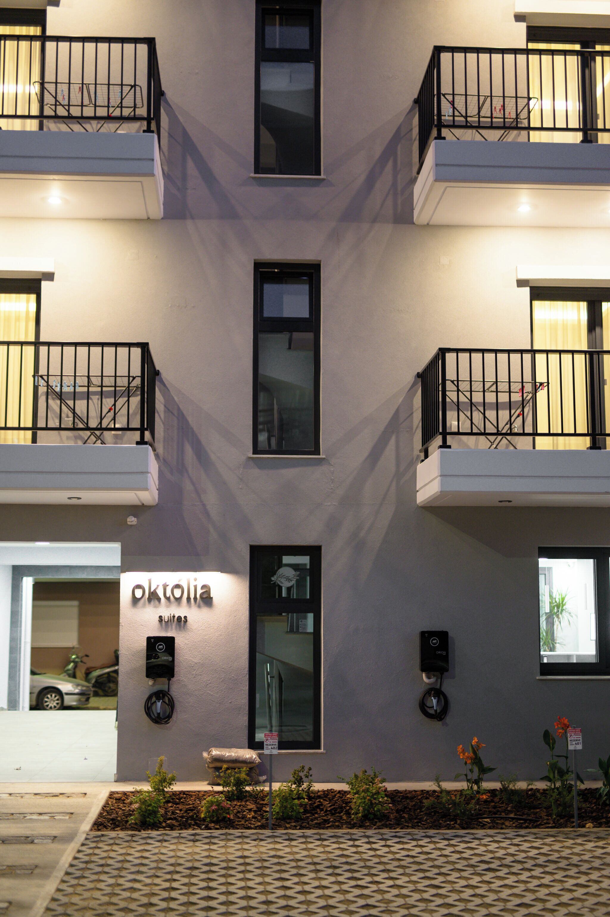 A modern building with a sign reading "oktolia suites" and a visible entrance.