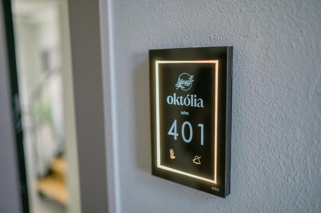 Un panell digital a la paret que mostra el número 401 d'una habitació a l'hotel októlia.