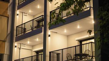 Un edificio de varios pisos con balcones, un letrero que dice “Oktolia” y una entrada bien iluminada.