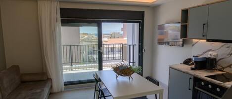 Una cocina moderna con comedor, sofá y balcón con vistas.