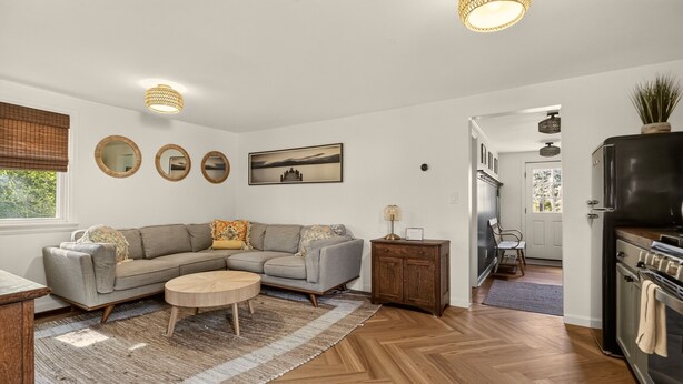 Een moderne woonkamer met een bank, salontafel en een eethoek met tafel en stoelen.
