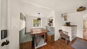 Une cuisine compacte avec une table en bois, un banc, une chaise et un coin café.
