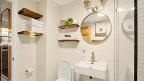 Un baño con inodoro, lavamanos y dos barras para toallas.