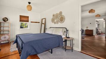 Une chambre à coucher avec un lit, une table de chevet et une vue sur l’extérieur par une fenêtre.