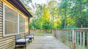 A wooden deck with two wicker chairs and a railing overlooking a forested area. - Cabin w/ Beach Access in Brant Lake: Dogs Welcome! (Brant Lake)