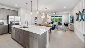 A modern kitchen with a large island, stainless steel appliances, and pendant lighting. - Eagle Trace Monroe: Water Park, Golf View, Near Disney (Kissimmee)