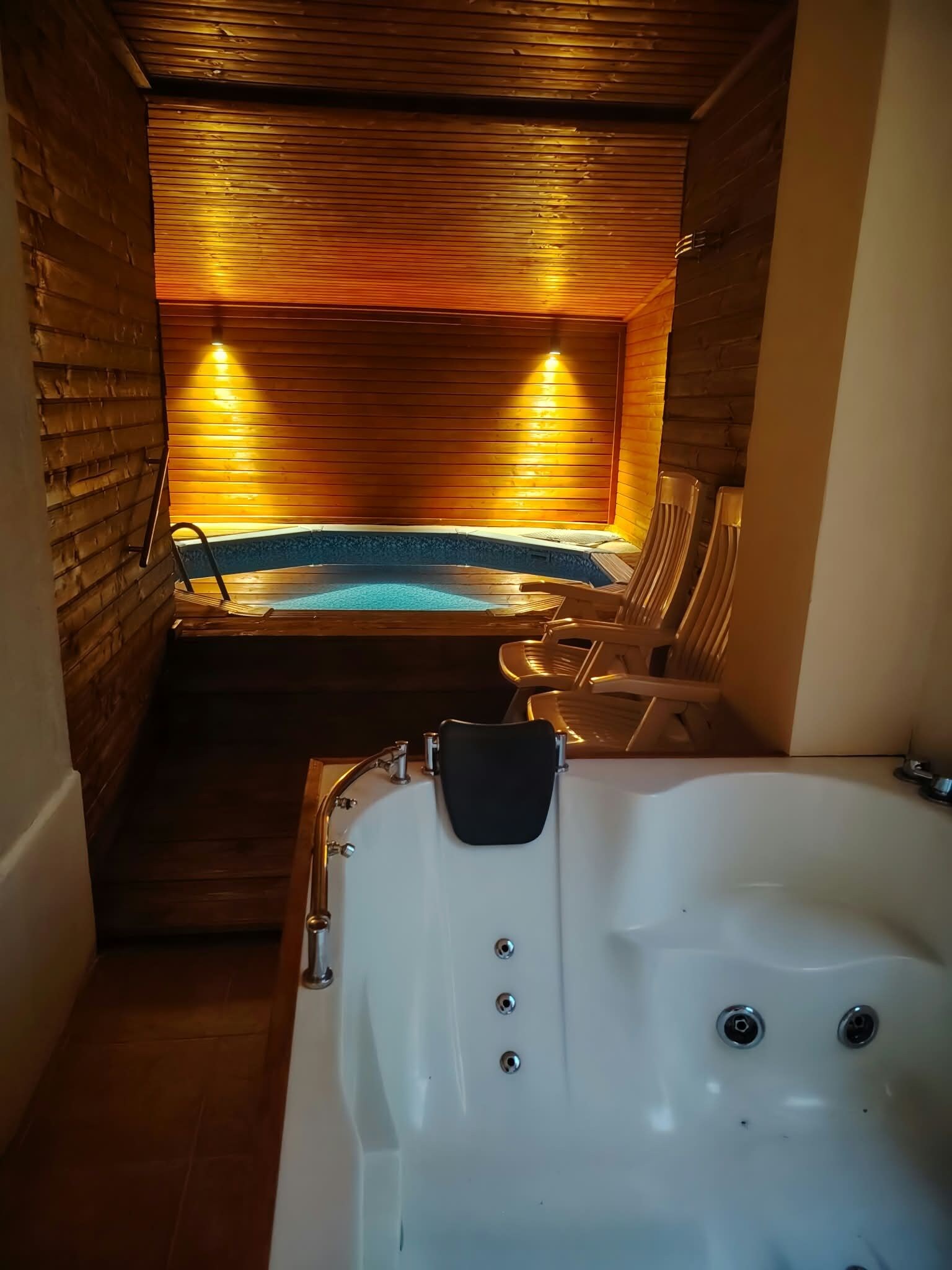 A spa area with a hot tub, wooden walls, and seating.