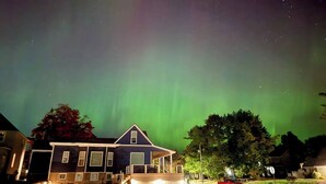 A house with a porch and steps leading up to it, under a night sky with visible stars. - Pristine Home Perfect for Family Bay Views Luxe Chef’s Kitchen Ludington Park (Escanaba)