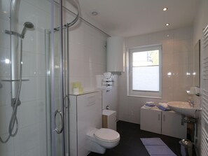 A modern bathroom with a glass-enclosed shower, a toilet, and a sink. - Apartment in Zugspitz Arena Near Highline 179 (Bichlbach)