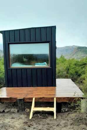 Enjoy a serene view from the elevated cabin, surrounded by nature.