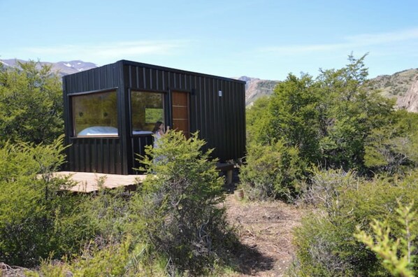 Escape to a secluded cabin nestled among lush greenery, offering a tranquil retreat with a view.