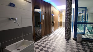 Ein Badezimmer mit Schachbrettboden, einem Waschbecken und einem Spiegel.