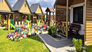 Eine Reihe von Holzhütten mit einem Spielplatz im Vordergrund.