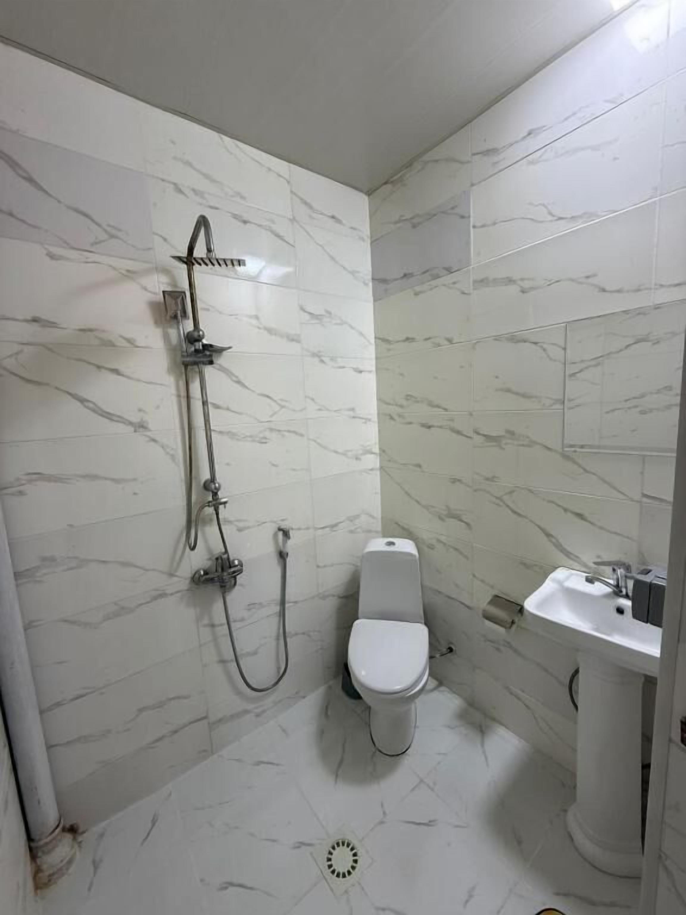 A bathroom with a shower, toilet, and sink.
