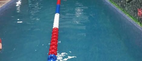 Een binnenzwembad en ligstoelen