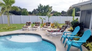 A swimming pool with lounge chairs and a patio area. - SALTWATER SMILES 3/2-HEATED POOL HOME 5 MILES FROM AMI WITH GAMES AND PING PONG. (BRADENTON,)