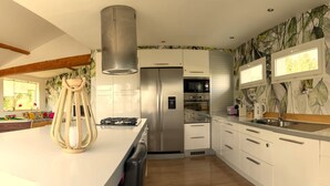 Une cuisine moderne avec des armoires blanches, des appareils en acier inoxydable et un grand îlot central.