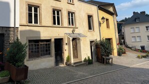 Ein Gebäude mit einem Kopfsteinpflasterhof, einer Holztür und Topfpflanzen.