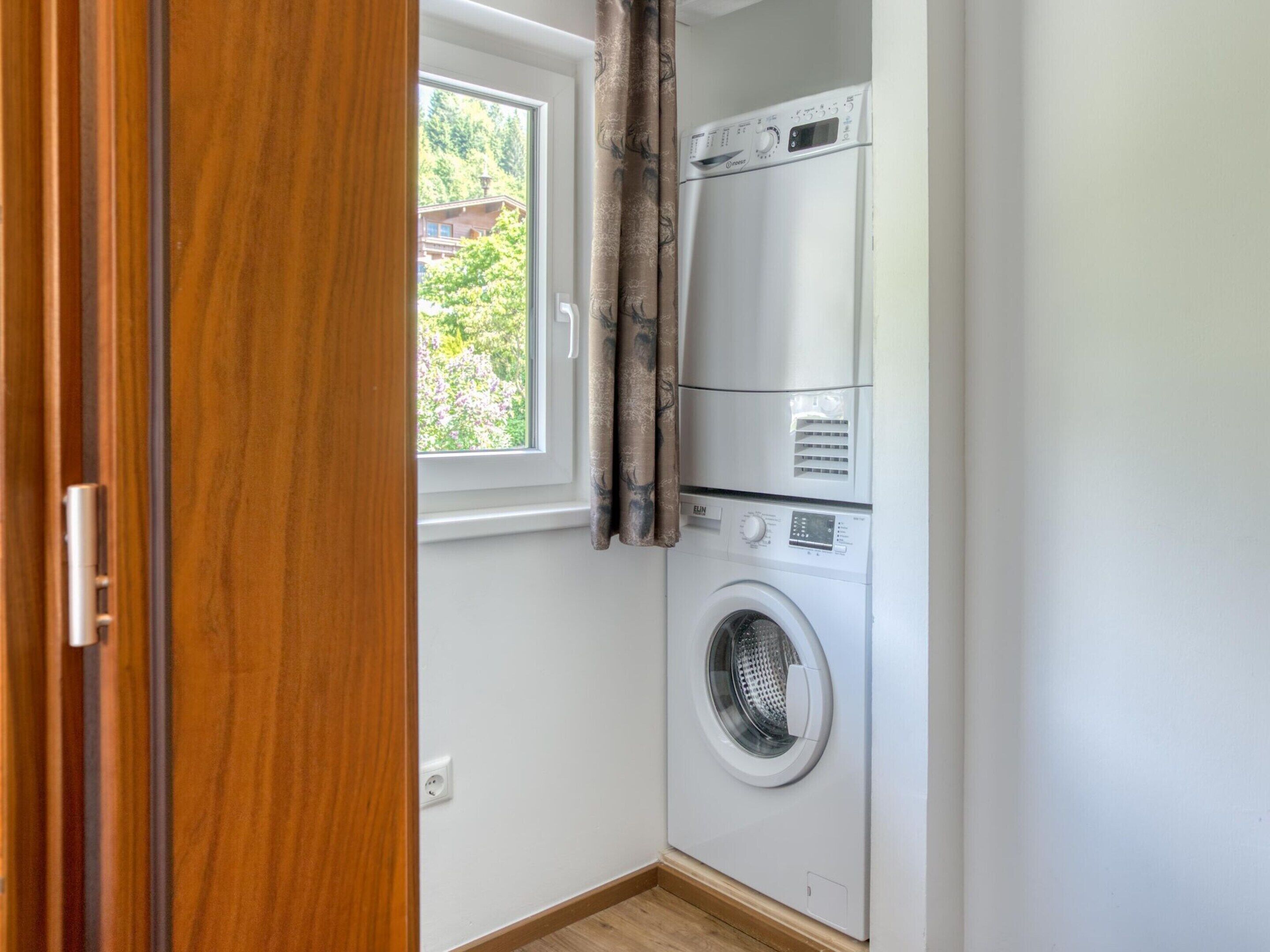 A compact laundry room with a front-loading washing machine and a stacked dryer.