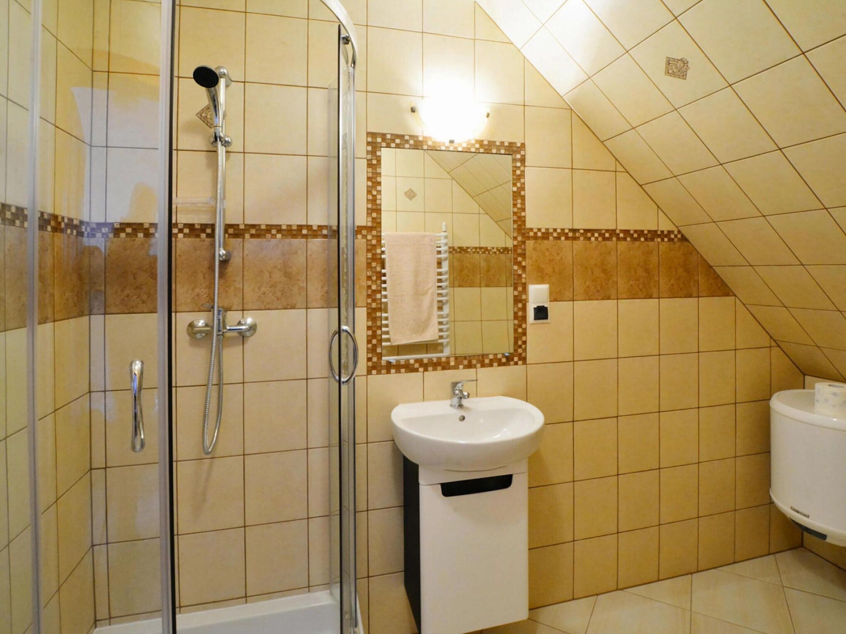 A bathroom with a shower, sink, and toilet.