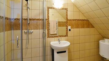 A bathroom with a shower, sink, and toilet.