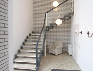 Una escalera de diseño moderno con pared de ladrillo y barandilla minimalista.