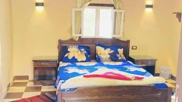 A bedroom with a wooden bed, checkered floor, and two bedside tables.