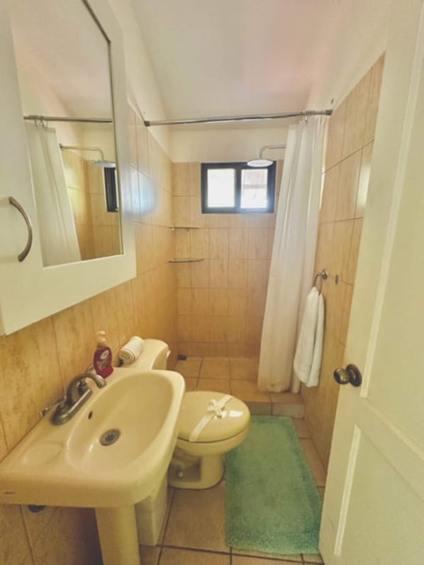 A bathroom with a sink, toilet, shower, and a mirror. - Flamenco Rosa B14 fully equipped condo w/ pool - short walk to the beach (Del Coco Beach)