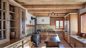 Una cocina con armarios de madera, una isla central y un amplio ventanal con vistas a la montaña.
