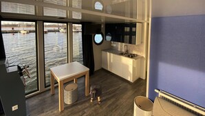 A compact kitchen with a sink, stove, and window overlooking a body of water. - Hausboat Kamien Pomorski on the Water (Kamien Pomorski)