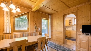 A wooden interior with a dining table, chairs, a television, and a kitchen area. - Chalet in Mayrhofen Near Ski Slopes (Brandberg)