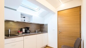 A compact kitchen with a skylight, a coffee maker, and a sink. - Apartment in Dorf Tirol Near Tirol Castle (Tirolo)